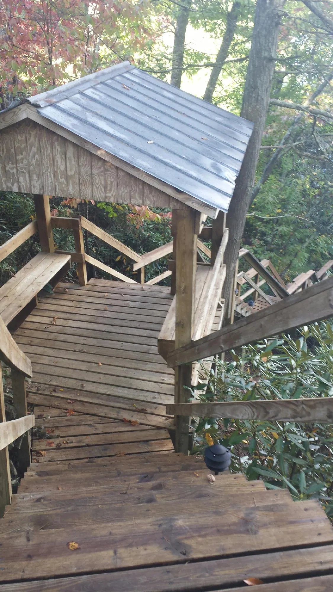Metal roofed shelter over wooden steps on a wooded walkway — Skylight Repair & Installation work by our crew in Edinburgh