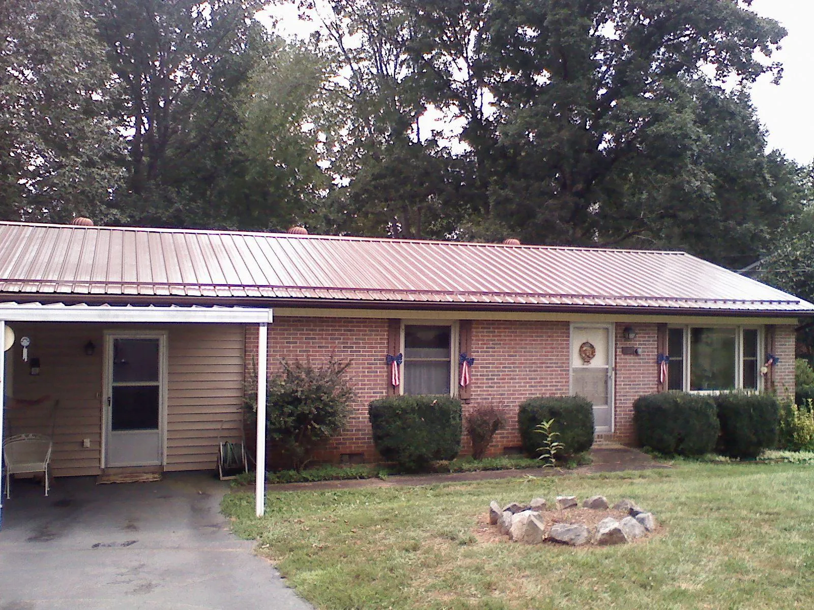 Bronze metal roof and carport on a brick ranch home — Roof Repair work by our crew in Edinburgh